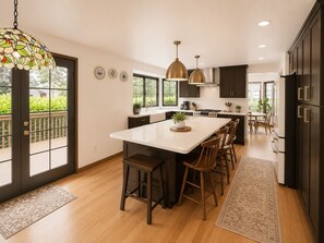 A modern kitchen with a central island, dark cabinetry, and pendant lighting. - World Cup Cozy Family Retreat, 4BR, 3 Living Rooms, Deck & Fenced Yard (Everett)