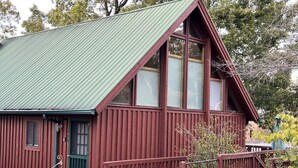 A wooden cabin with a green roof, a front porch, and a small deck. - LAKE KEOWEE WATERFRONT! ONLY 15 feet from
Shore. Price includes BOAT SLIP (Six Mile)