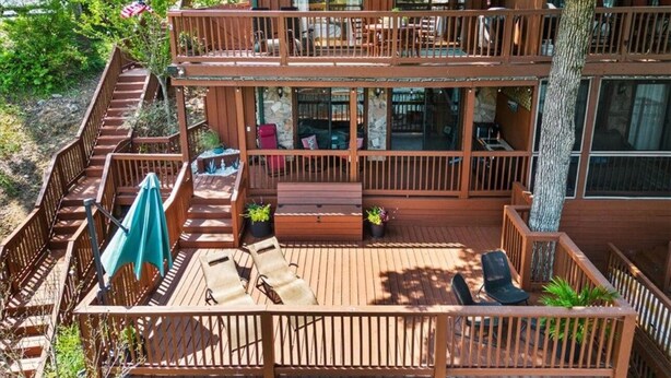 A two-story wooden cabin with a deck, outdoor seating, and a staircase. - LAKE KEOWEE WATERFRONT! ONLY 15 feet from
Shore. Price includes BOAT SLIP (Six Mile)