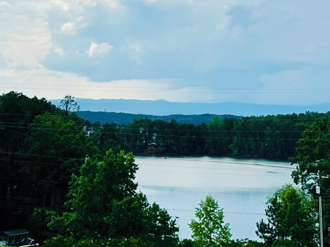 A lake surrounded by trees and hills.