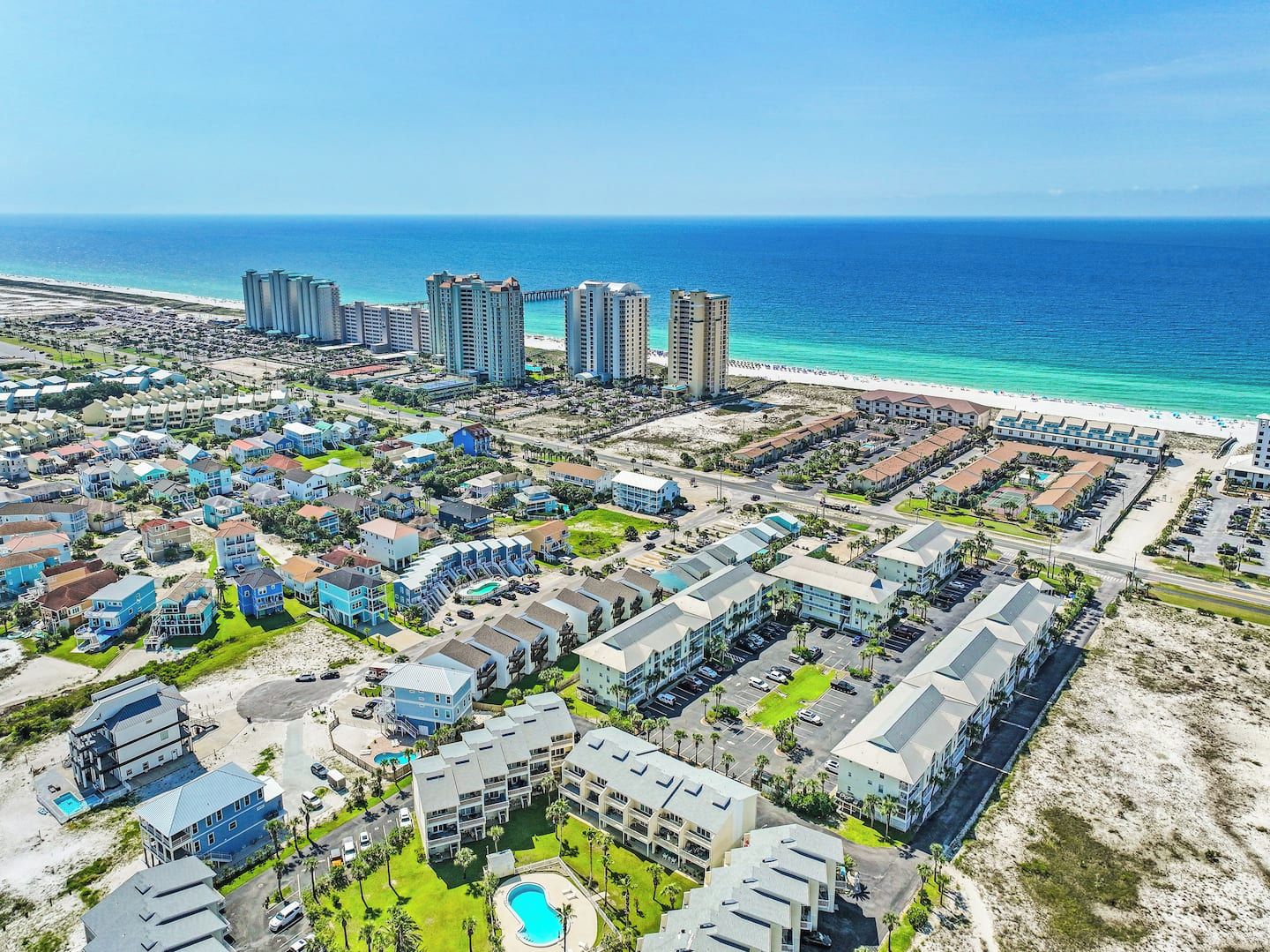 A coastal residential area with beachfront properties, including multi-story buildings and single-family homes.