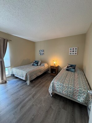 A bedroom with two beds, a nightstand, a lamp, and artwork on the walls. - 2Bed2Bath Condo w/ Fairway Views on No. 5: Walk to Club, Cradle & Harness Track (Pinehurst)
