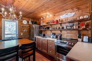 A rustic kitchen with wooden walls, a chandelier, and a sign reading "Scratch Kitchen."