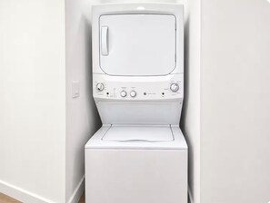 A white washing machine with a control panel and a door. - Wilton Manors • Las Olas • Beach • Downtown FTL (Fort Lauderdale)