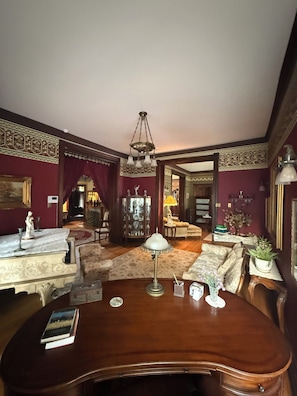 Une pièce avec une table en bois, une lampe, un canapé et un miroir décoratif.