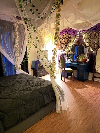 A bedroom with a bed, a desk, and a chair.. Victorian Fairy Cottage