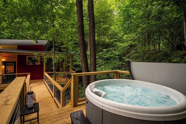 A wooden deck with a hot tub, surrounded by trees. - Terrace Creek Retreat | Creekside Hot Tub Escape | 5 Min From Nada Tunnel! (Stanton)