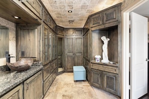 A spacious bathroom with wooden cabinetry, a granite countertop, and a marble floor. - Lakefront Oasis | Infinity Edge Pool & Golf Views (Glendale)