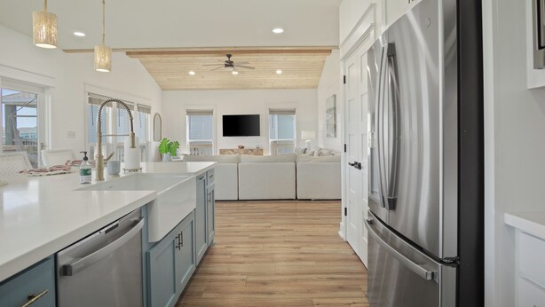 Una cocina moderna con una isla central, electrodomésticos de acero inoxidable y un ventilador de techo.