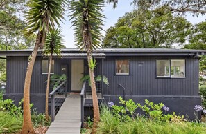 A modern house with a dark exterior, a front door, and a small porch area. - Coastal Sanctuary (Anglesea)