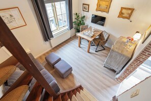 Ein modernes Wohnzimmer mit einer Couch, einem Esstisch und einem Fernseher.