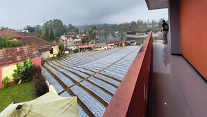 A balcony with a view of a river and surrounding buildings.