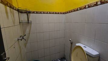 A small bathroom with a toilet, a sink, and a window.