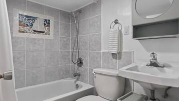 Un baño con bañera, inodoro y lavamanos.