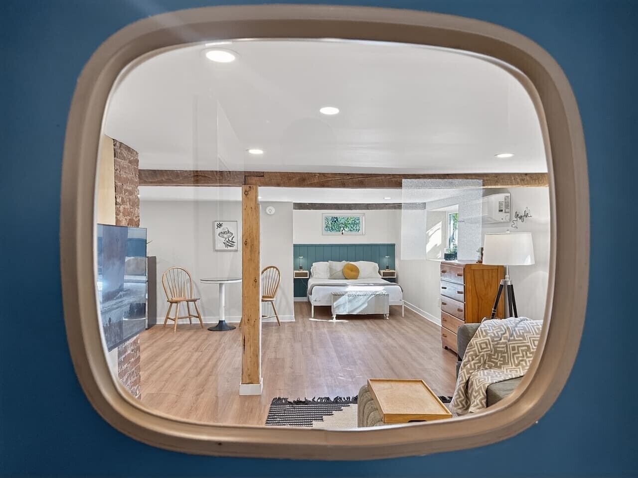 A room with a bed, a desk, a chair, and a mirror.