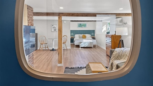 Una habitación con cama, escritorio, silla y espejo.