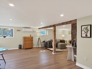 Una habitación amplia con piso de madera, un sofá, una mesa de centro y una lámpara.