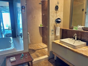 A bathroom with a bathtub, a shower, a sink, and a mirror. - Spacious 4-Bedroom Grand Luxxe Retreat, Perfect for Families and Groups (Nuevo Vallarta)