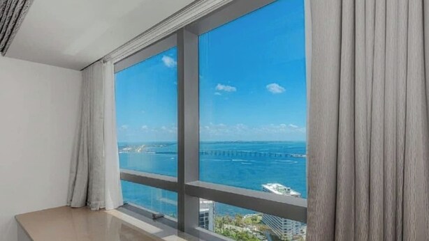 Ein Zimmer mit großem Fenster und Blick auf die Küste, inklusive Brücke und Gebäuden.
