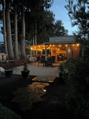 A rustic outdoor seating area with tables and chairs, surrounded by trees and a small water feature. - Superb 5 -bedroom Estate in Monroe perfect for family getaways (Monroe)