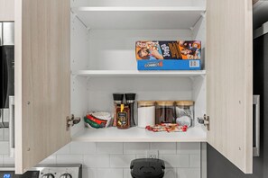 A kitchen with a coffee maker, jars, and a Connect4 game box. - The Nook - 20 mins from airport | Games | Coffee (Edmonton)