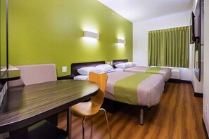Hotellihuone, jossa on kaksi sänkyä, työpöytä, tuoli ja televisio.