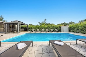 A swimming pool with lounge chairs, a covered seating area, and a small shed. - Villa LanaB – Private Pool and Great Location by Istrabook (Labin)