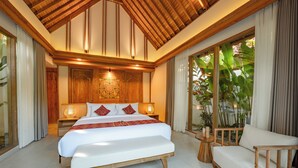 Een slaapkamer met een groot bed, houten plafond en uitzicht op groen.