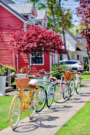 Bicycles parked on a sidewalk with a red building in the background. - Bright second-floor home with private deck, modern kitchen, and calm style. (Charlottetown)