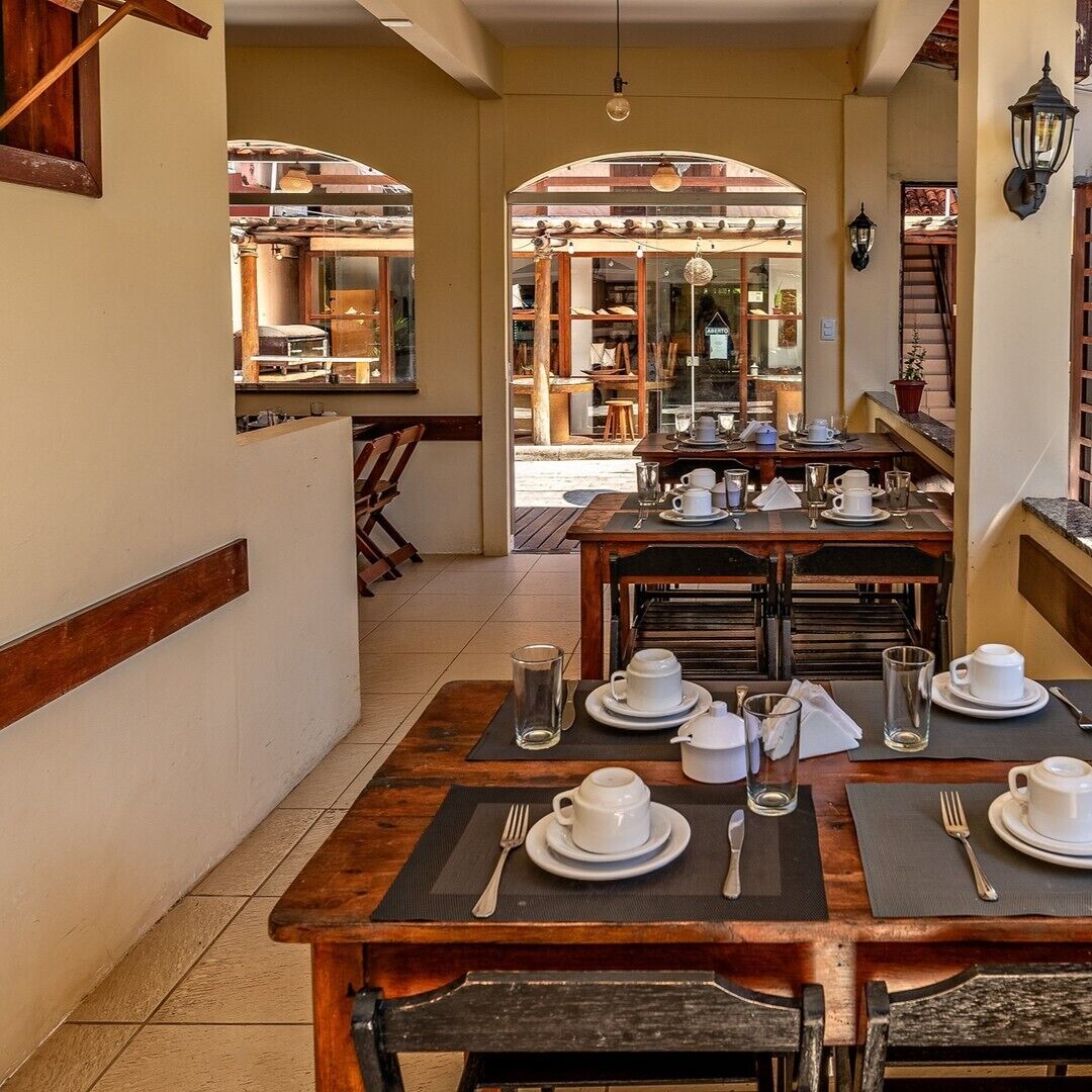 A dining area with tables set for service, a view of the outdoor seating area, and a staircase leading to an upper level.