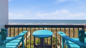 Ein Balkon mit Blick auf Strand und Meer.