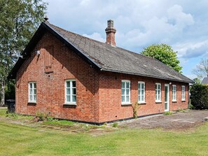 A red brick building with a pitched roof, multiple windows, and a chimney. - 6 Person Holiday Home in Odder (Odder)