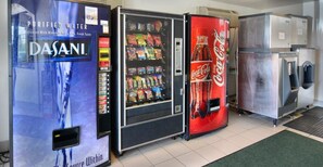 A vending machine area with a Dasani water dispenser, a snack vending machine, and a Coca-Cola cooler. - Budget-Friendly Studio Close to Downtown West Palm Beach – 3 Miles (West Palm Beach)