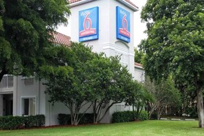 A building with two large blue signs reading 'studio 6 extended stay' and 'WiFi here'.