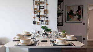 Une table à manger dressée avec des bols, des verres et une petite plante.
