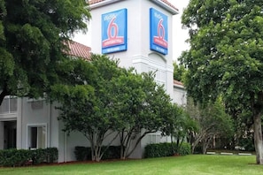 A building with two large blue signs reading 'studio 6 extended stay' and 'WiFi here'.