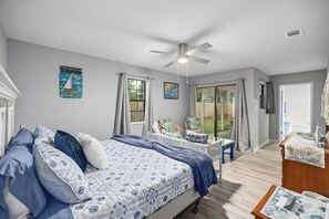 Ein Schlafzimmer mit einem Bett, einem Sessel, einem Tisch und einem Kleiderschrank.