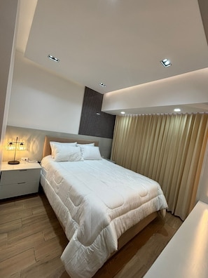 A modern bedroom with a bed, bedside table, and a nightstand. - Apartamento moderno en Quetzaltenango (Quetzaltenango)