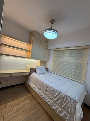 A bedroom with a bed, a desk, and a ceiling light. - Apartamento moderno en Quetzaltenango (Quetzaltenango)