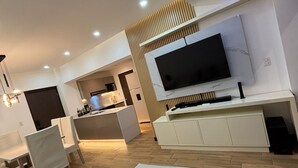 A modern living room with a sofa, TV, and wooden accents. - Apartamento moderno en Quetzaltenango (Quetzaltenango)