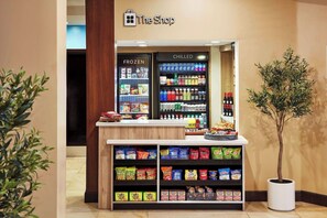En kiosk med et udvalg af frosne og kolde varer, herunder pølser, chips og drikkevarer.