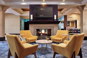A lobby with a fireplace, seating area, and a shop. - Premium Corner Room with 2 Queens | 4.5 Miles to Towsley Canyon Nature Trails (Valencia)