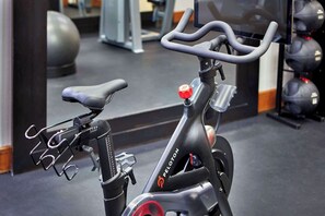 A stationary exercise bike with a digital display, handlebars, and a seat.