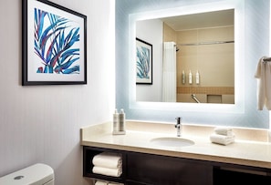 A bathroom with a sink, mirror, framed artwork, and toiletries. - Large King Room | Private Balcony with Pool Views | 1.1 Miles to Local Golf (Valencia)
