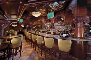 A bar area with wooden furniture, a bar counter, and a television screen. - Spacious Mountain Resort Room w/ Seven Pools & Private Cabanas (Phoenix)