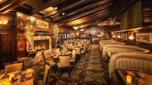 A restaurant with a fireplace, multiple dining tables, and cushioned seating areas. - 2 Cozy Mountain Resort Rooms Surrounded by Mountains w/ 138-Foot Water Slide (Phoenix)