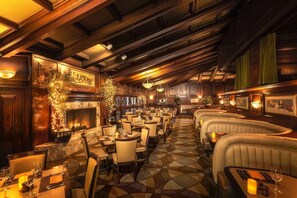 A restaurant with a fireplace, multiple dining tables, and cushioned seating areas. - 2 Cozy Mountain Resort Rooms Surrounded by Mountains w/ 138-Foot Water Slide (Phoenix)