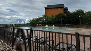 A pool area with lounge chairs and a wooden building in the background. - Cozy Smoky Mountain Fall Escape! 1BR Westgate Resort + Water Park - Sleeps 4 (Gatlinburg)