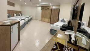 A hotel room with a bed, bedside table, desk, and a mirror. - Snood Al-dana (Makkah)
