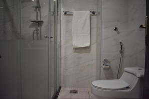 A bathroom with a glass-enclosed shower, a toilet, and a towel rack. - Snood Al-dana (Makkah)